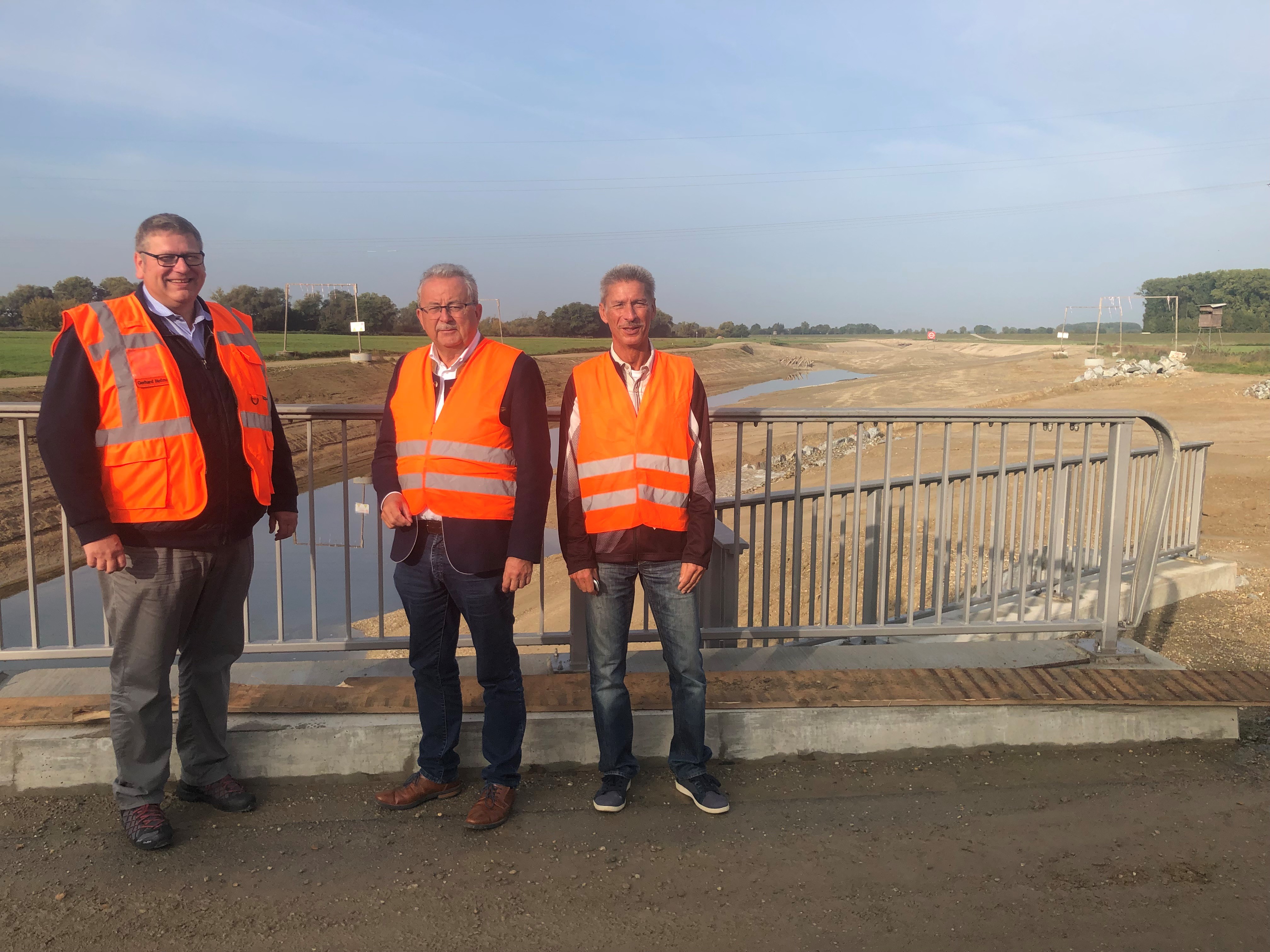 Gerhard Hofmann (Leiter Bauausführung WIGES GmbH), Uwe Roth (Leiter Sachgebiet Wasserrecht am Landratsamt), Landrat Josef Laumer (von links) stehen am neuen Auefließgewässer.