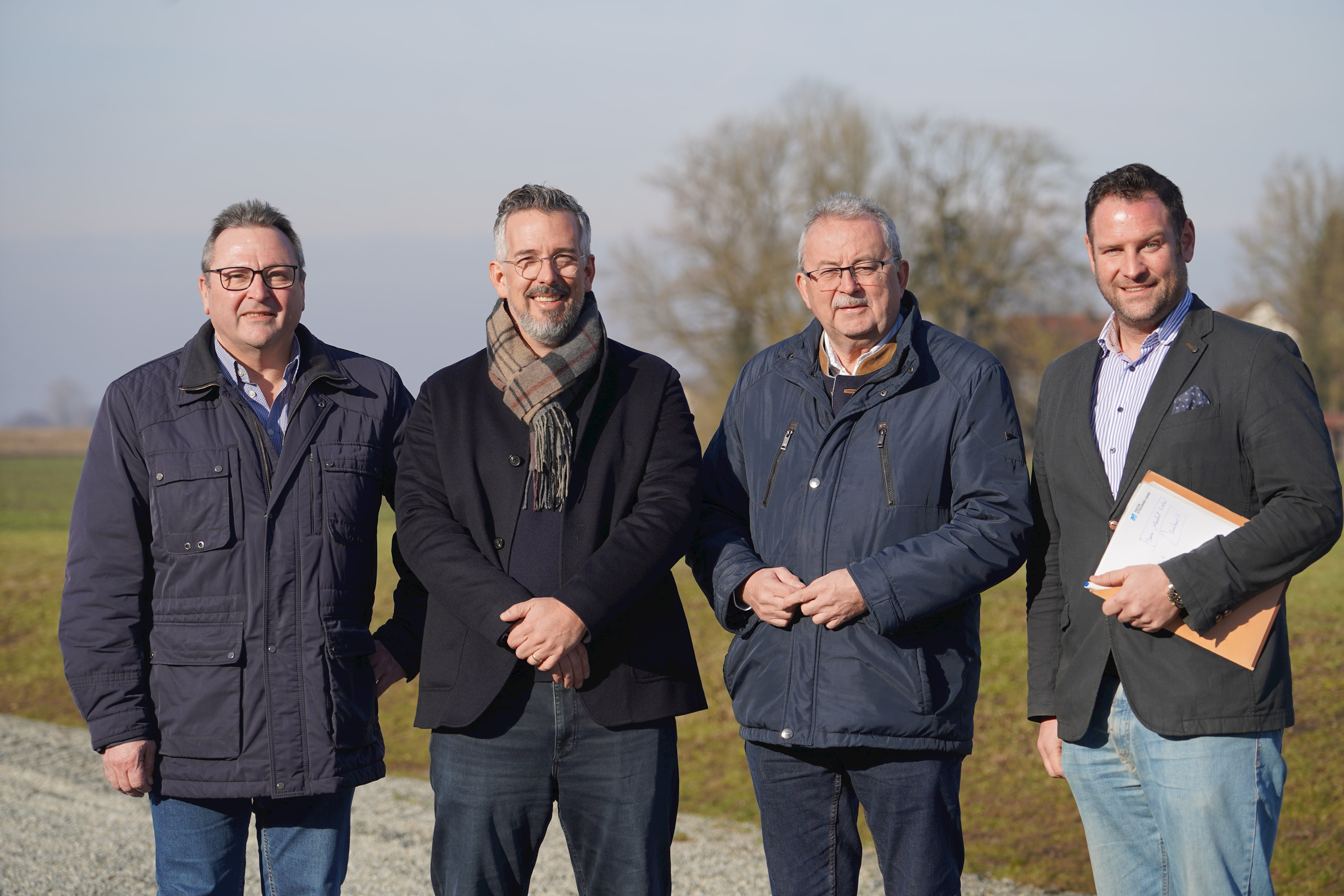 Johann Retzer (Leitung Saatgut & Vertrieb), Alexander Strube (Geschäftsführer), Landrat Josef Laumer und Wirtschaftsreferent Martin Köck stehen auf dem Betriebsgelände von Ackermann Saatzucht.
