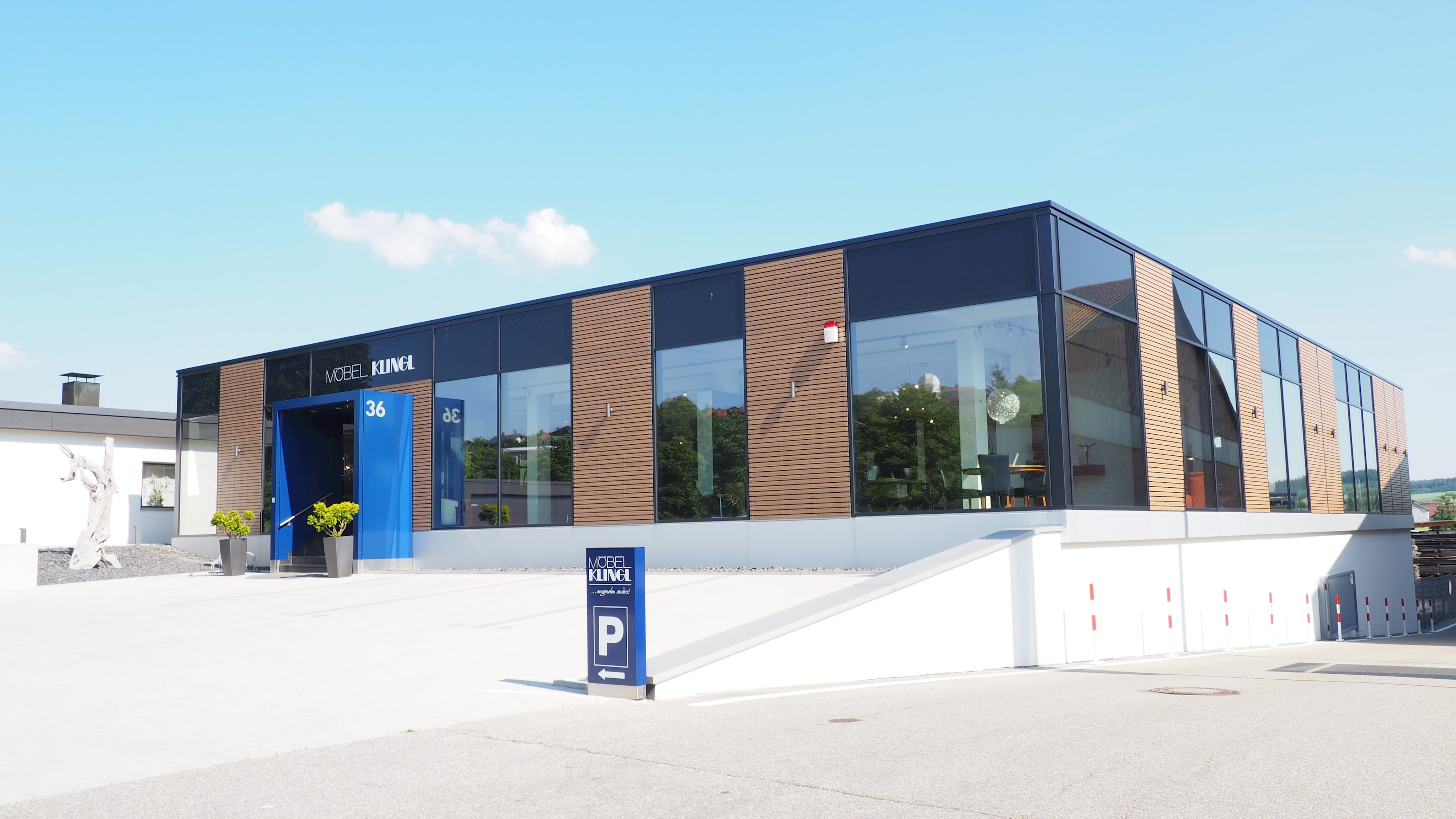 Das Bild zeigt das Firmengebäude der Firma Möbel Klingl mit Eingang und Parkplatz
