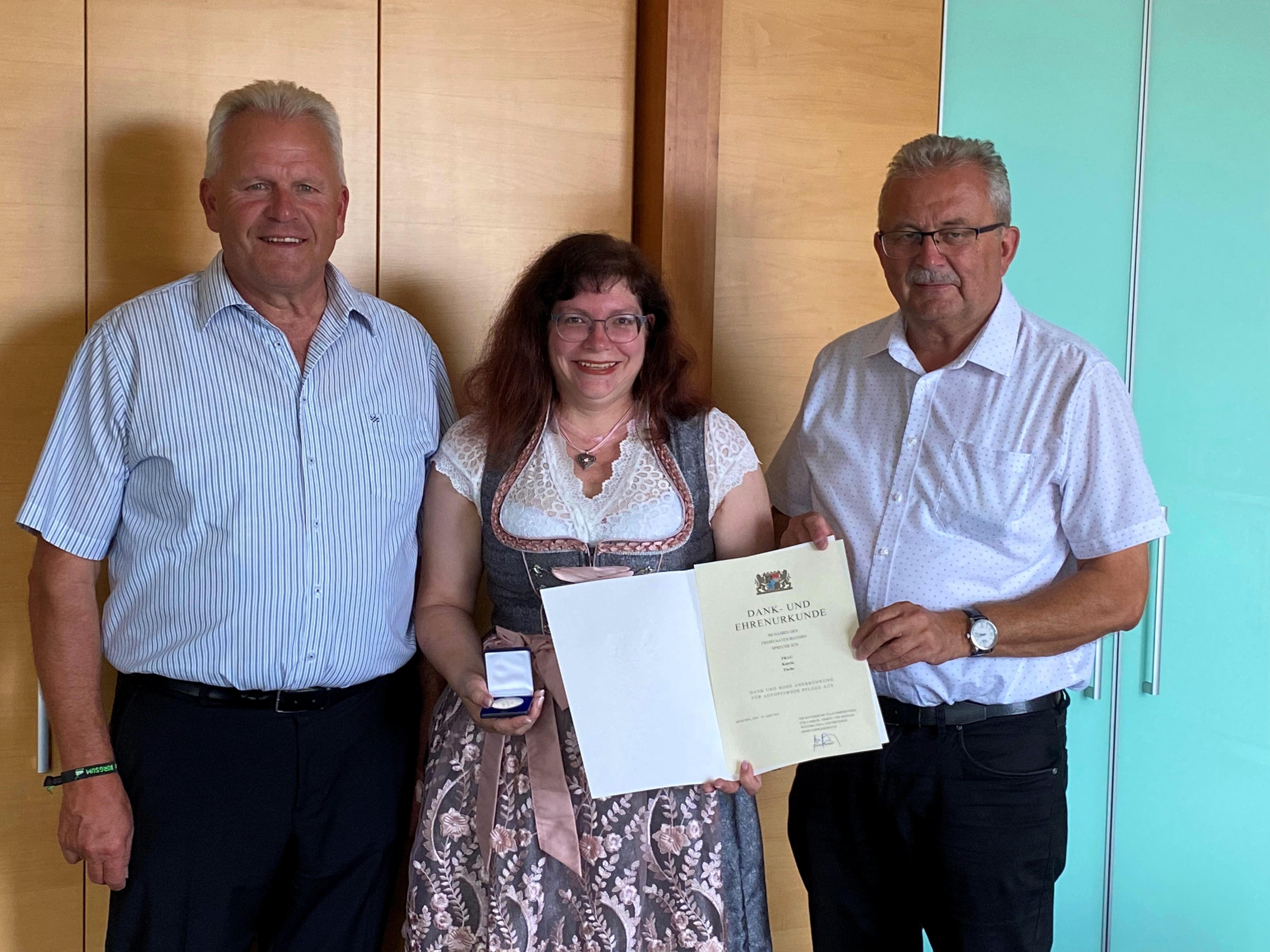 Katrin Fuchs gemeinsam mit Landrat und Bürgermeister nach ihrer Auszeichnung im Büro des Landrats.