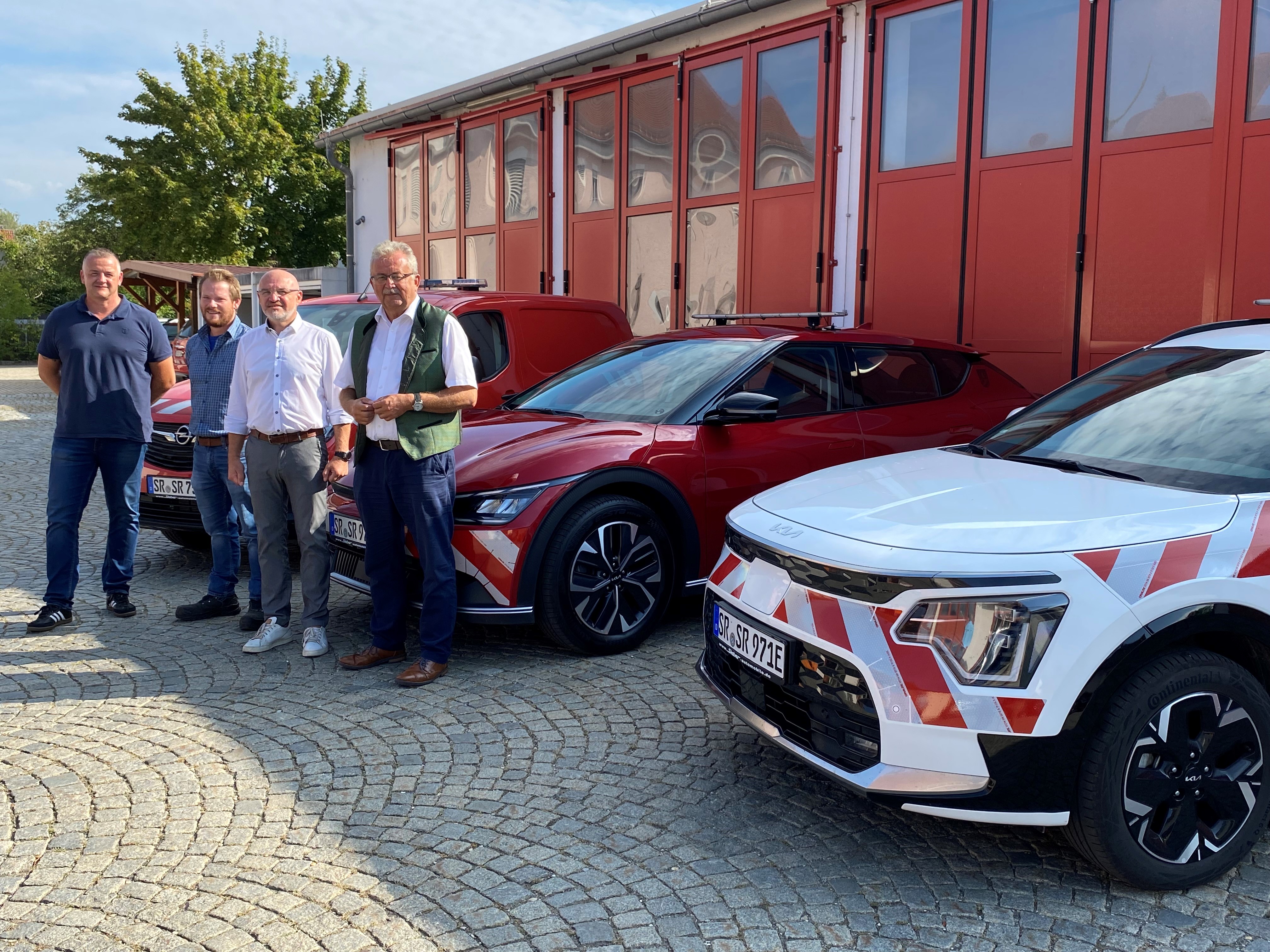 Markus Heilmann (Leiter Bauhof Bogen), Matthias Linsmeier (Leiter Bauhof Ittling), Markus Fischer (Leiter Tiefbauverwaltung) und Landrat Josef Laumer vor den drei neuen E-Fahrzeugen.