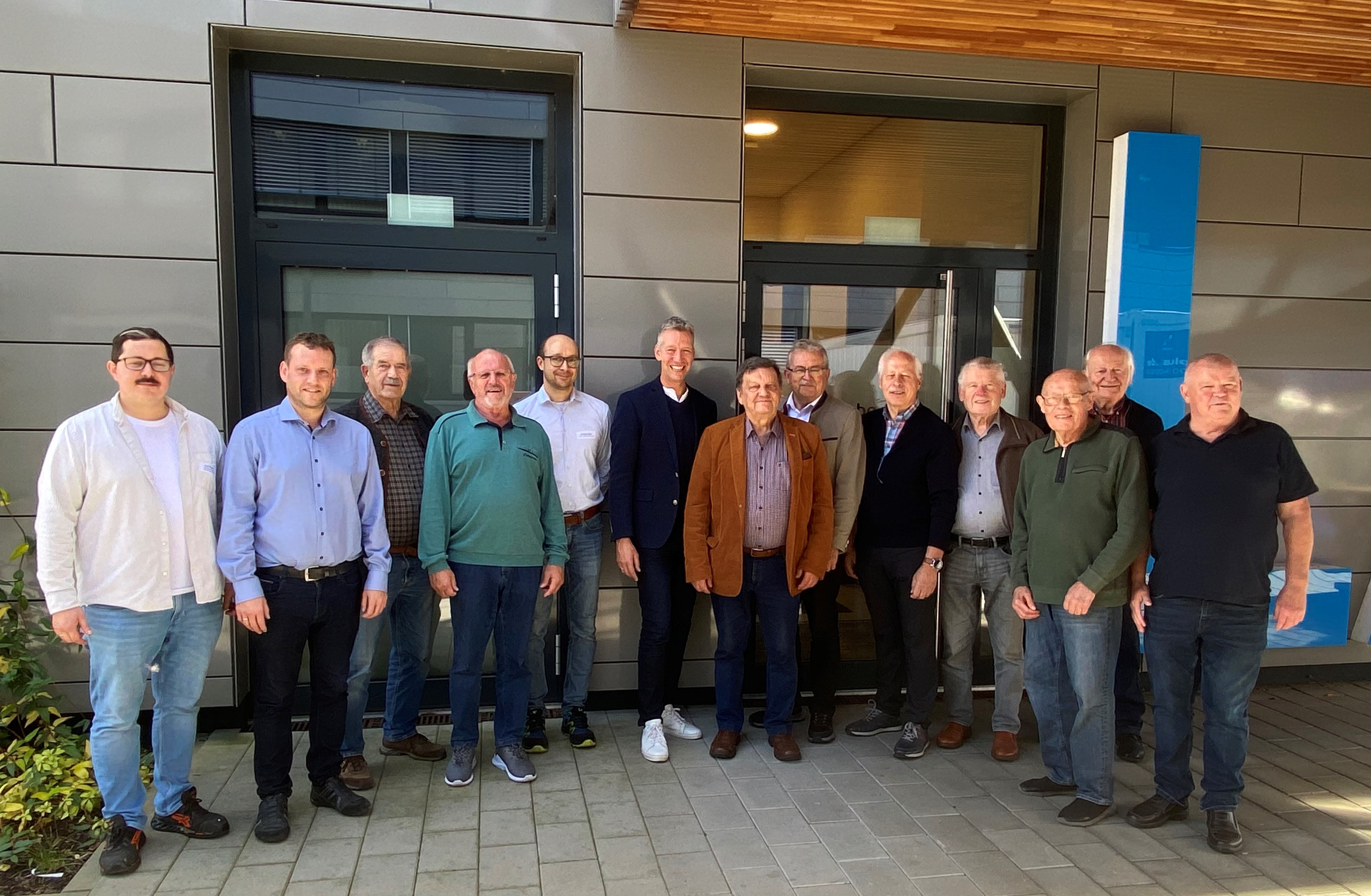 Die ehemaligen Feuerwehr-Führungsdienstgrade des Landkreises gemeinsam mit Landrat Josef Laumer sowie Kai Peters, Wolfgang Zisler und Christian Wagner vor dem Betriebsgebäude der Firma Wallstabe & Schneider in Niederwinkling.