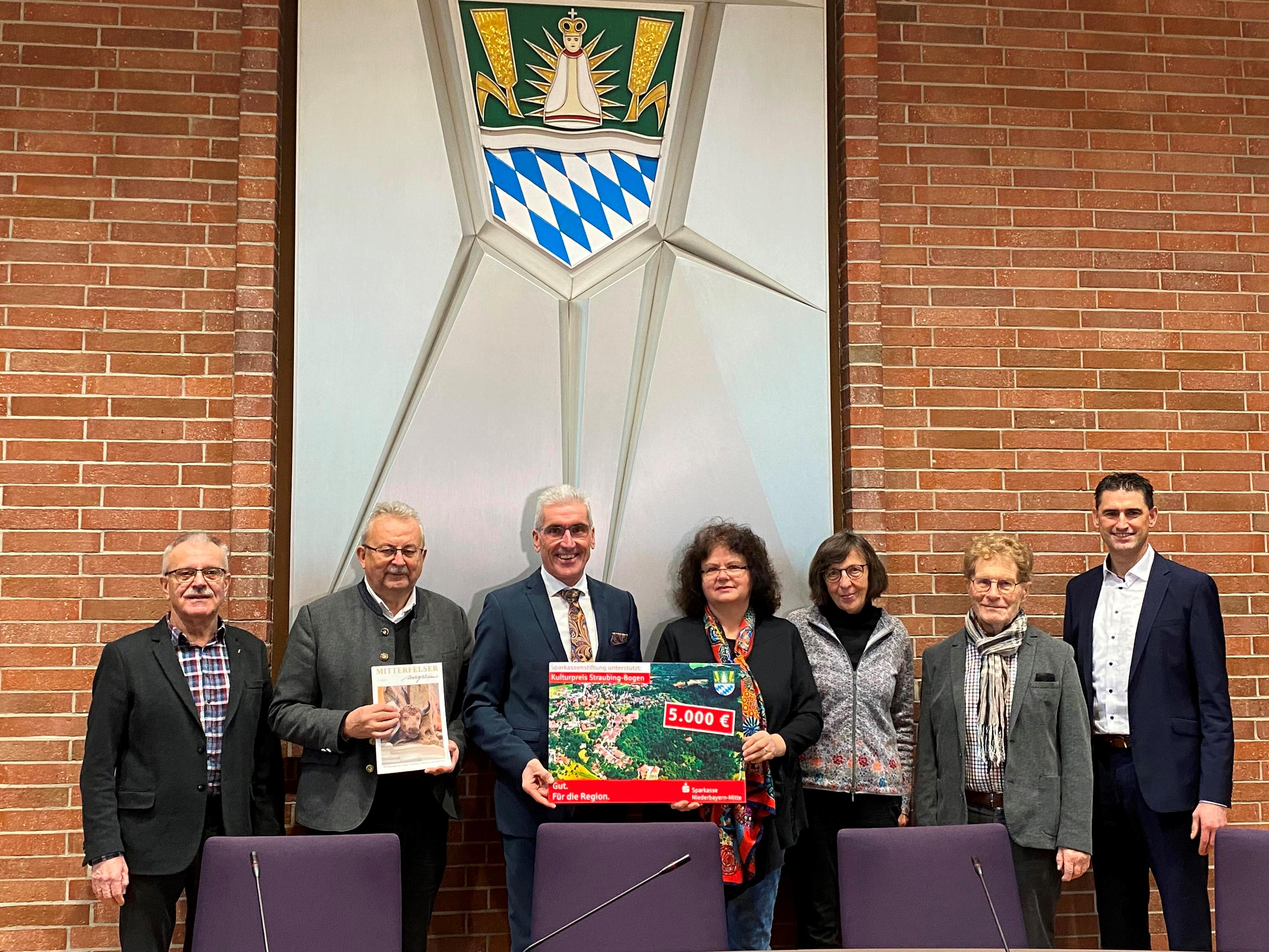 Altbürgermeister Heinrich Stenzel, Landrat Josef Laumer, Vorstandsvorsitzender Walter Strohmaier, Elisabeth Vogl (1. Vorsitzende), Gertrud Graf (Kassiererin), Franz Tosch (ehemaliger 1. Vorsitzender und 28 Jahre verantwortlich für das Mitterfelser Magazin) und Bürgermeister Andreas Liebl bei der Spendenübergabe im Landratsamt.